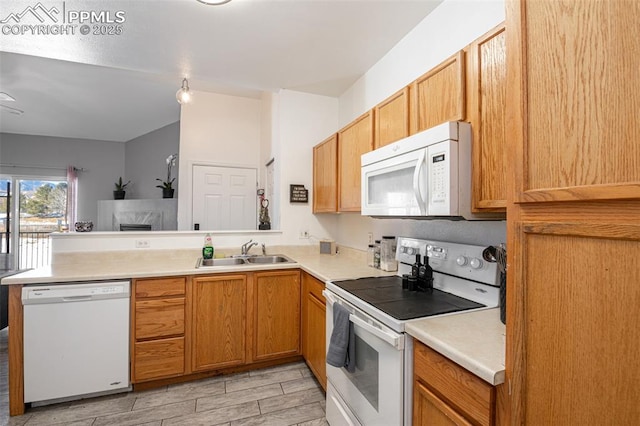 kitchen with sink, white appliances, and kitchen peninsula