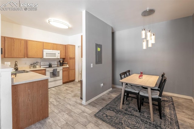 kitchen with sink, hanging light fixtures, electric panel, white appliances, and light hardwood / wood-style flooring