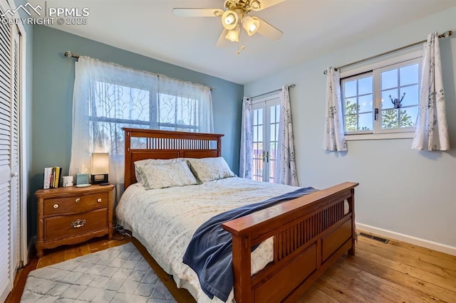 bedroom with french doors, ceiling fan, and light hardwood / wood-style flooring