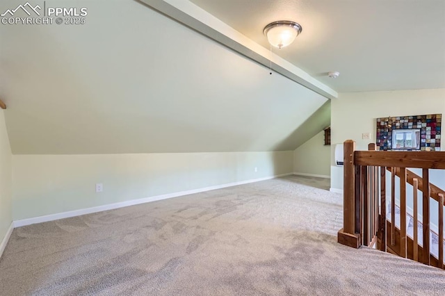 additional living space with vaulted ceiling with beams and carpet