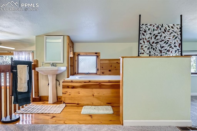 bathroom with a bathtub and a textured ceiling