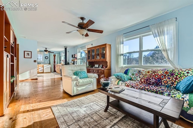 living room with light hardwood / wood-style flooring and ceiling fan