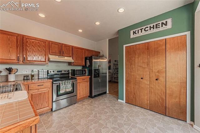 kitchen featuring sink, tile counters, and stainless steel appliances