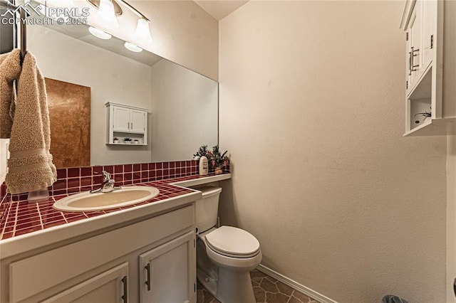 bathroom featuring vanity, backsplash, and toilet