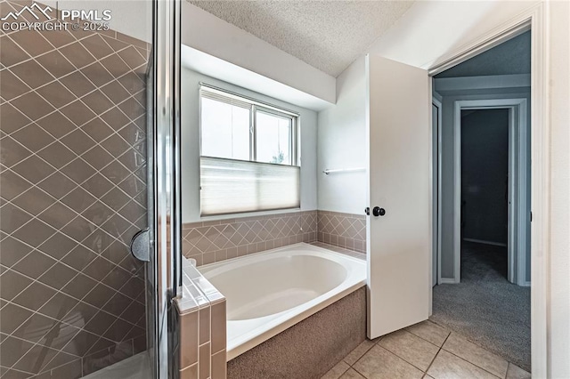 bathroom featuring tile patterned floors, shower with separate bathtub, and a textured ceiling