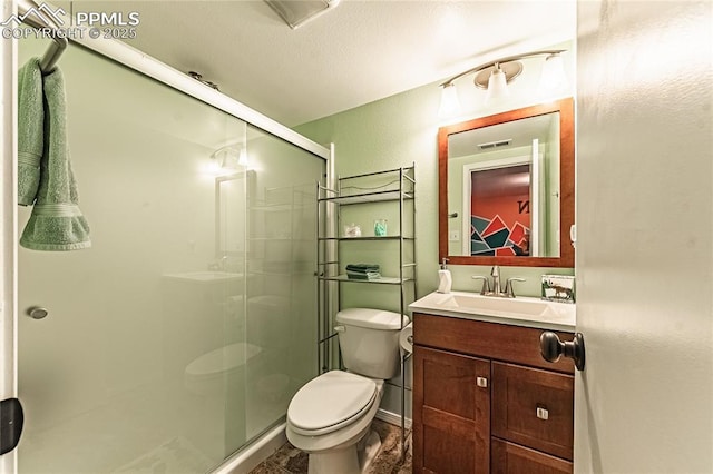 bathroom featuring vanity, walk in shower, and toilet