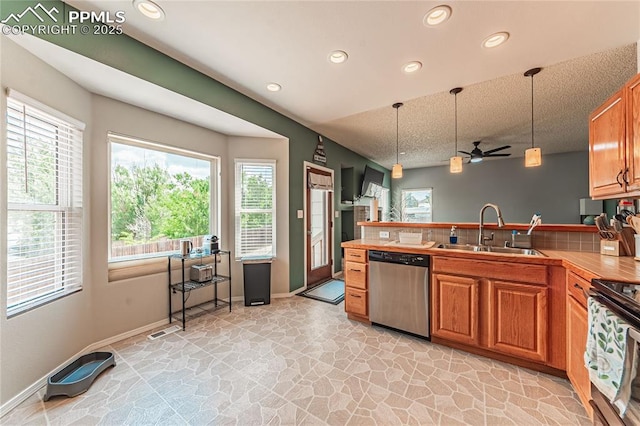 kitchen with dishwasher, sink, pendant lighting, and electric range