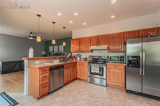 kitchen with sink, hanging light fixtures, appliances with stainless steel finishes, kitchen peninsula, and ceiling fan