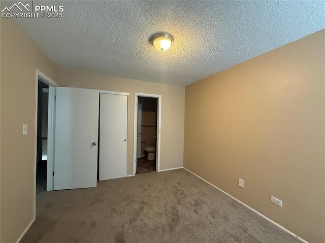 unfurnished bedroom with ensuite bath, carpet flooring, a closet, and a textured ceiling