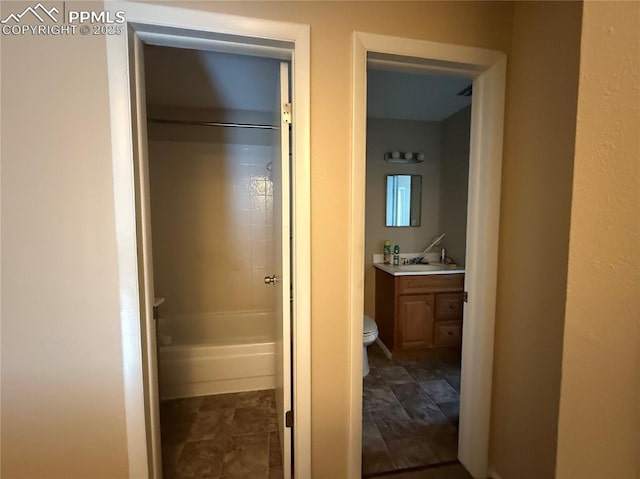 interior space featuring vanity, bathing tub / shower combination, and toilet