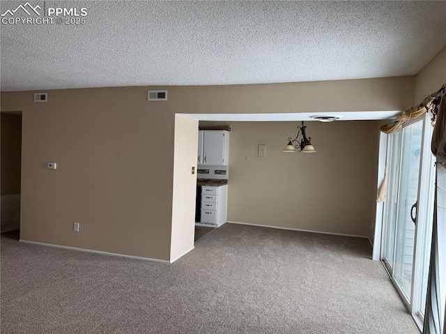 carpeted empty room featuring a textured ceiling