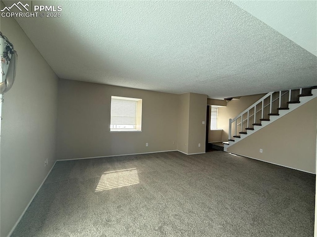 unfurnished living room featuring carpet floors, a healthy amount of sunlight, and a textured ceiling