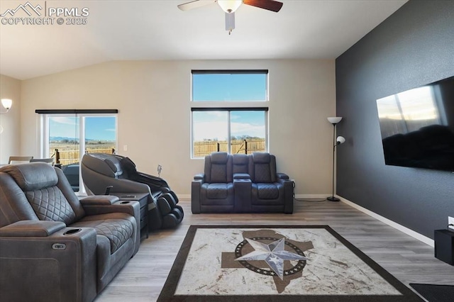 living room with hardwood / wood-style flooring, ceiling fan, and lofted ceiling