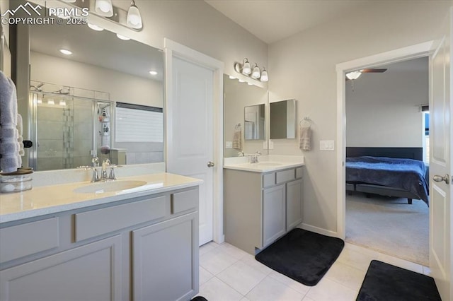 bathroom featuring a shower with door, vanity, tile patterned flooring, and ceiling fan