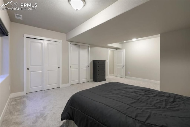 carpeted bedroom featuring multiple closets