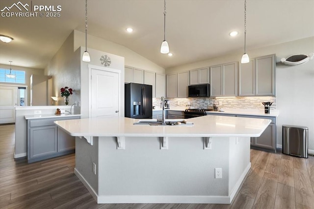 kitchen with a spacious island, gray cabinetry, and black appliances