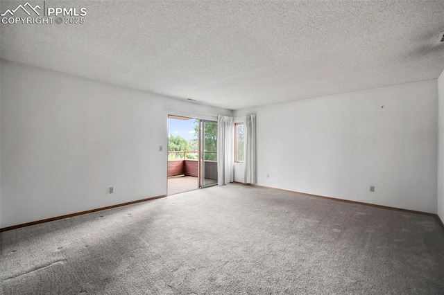 carpeted empty room with a textured ceiling