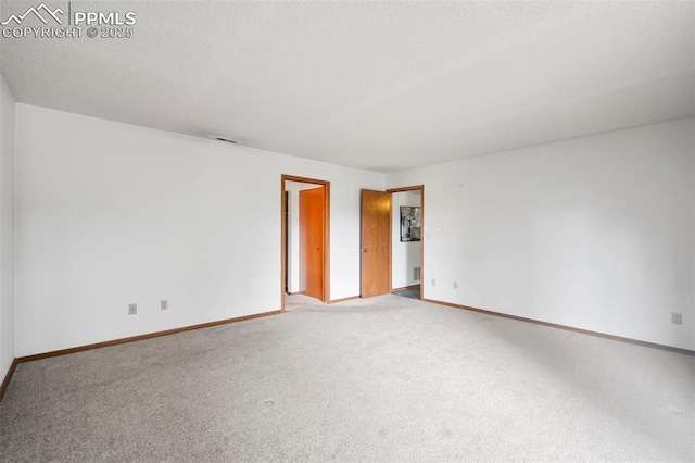 unfurnished room featuring carpet flooring and a textured ceiling