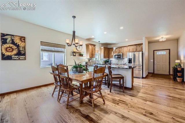 dining space with an inviting chandelier and light hardwood / wood-style flooring