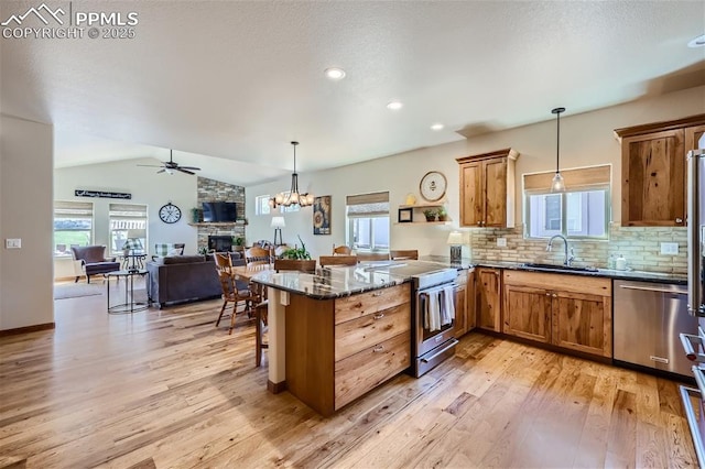 kitchen featuring a breakfast bar, sink, kitchen peninsula, pendant lighting, and stainless steel appliances