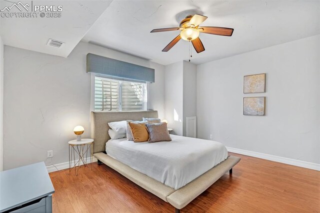 bedroom with hardwood / wood-style floors and ceiling fan