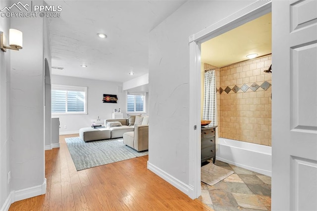 bathroom with hardwood / wood-style flooring and shower / tub combo with curtain