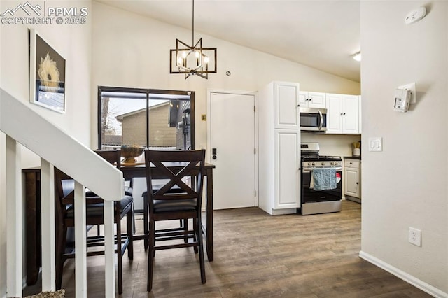 dining area with wood-type flooring, high vaulted ceiling, and an inviting chandelier