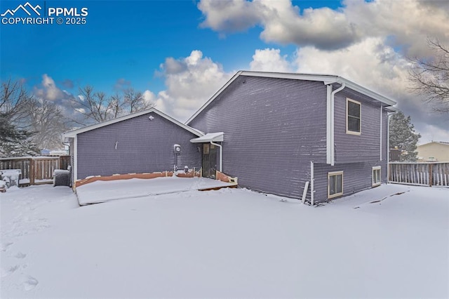 view of snow covered back of property