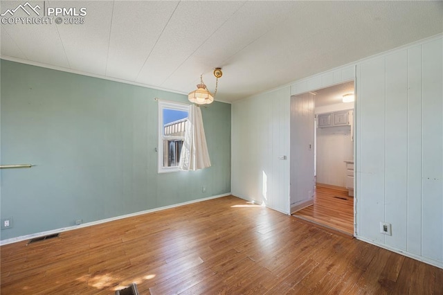 empty room featuring hardwood / wood-style flooring and crown molding