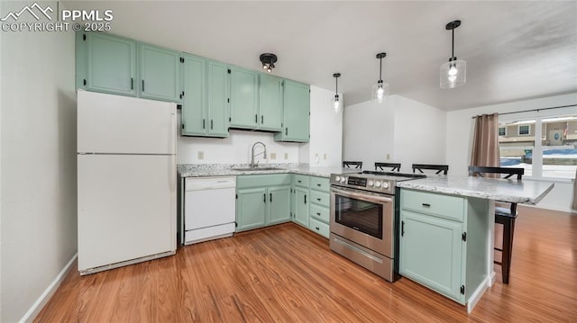 kitchen featuring sink, hanging light fixtures, a kitchen breakfast bar, kitchen peninsula, and white appliances