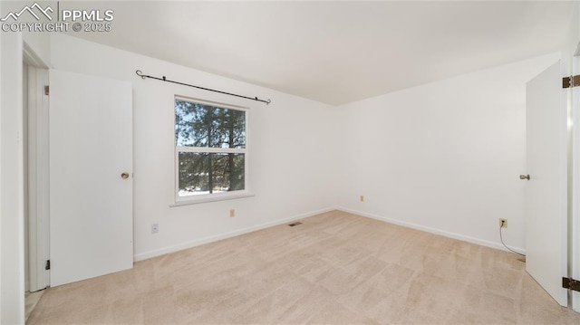 unfurnished room featuring light colored carpet