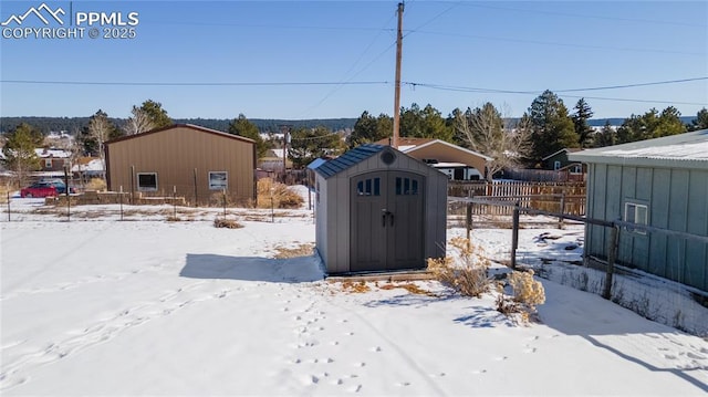 yard covered in snow with a storage shed