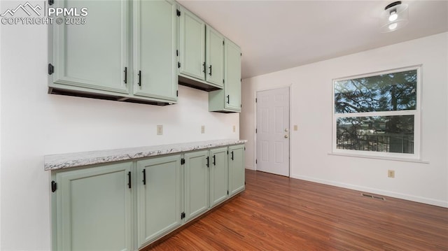 kitchen featuring light stone counters and wood-type flooring