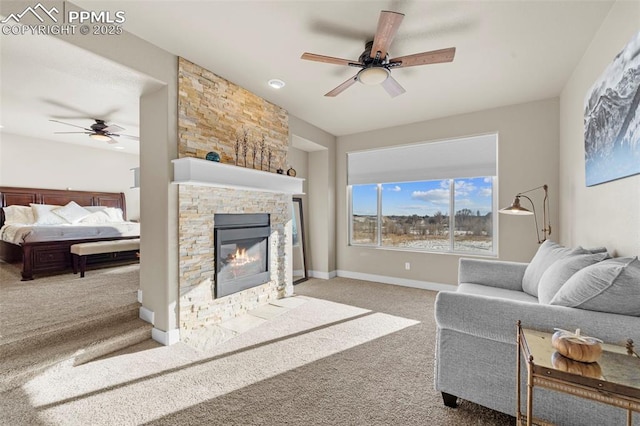 living room with ceiling fan, a stone fireplace, and light carpet