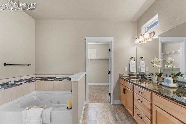 bathroom with vanity, a tub to relax in, and hardwood / wood-style floors