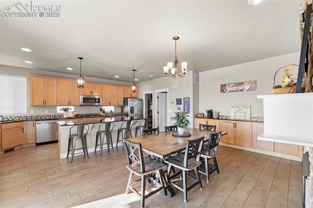 dining room with a chandelier and light hardwood / wood-style flooring