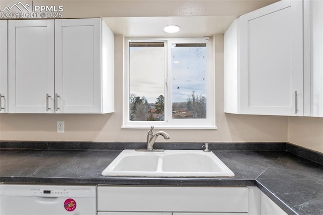 kitchen featuring white dishwasher, sink, and white cabinets