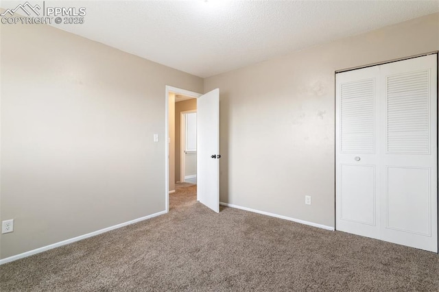 unfurnished bedroom featuring a closet, a textured ceiling, and carpet flooring