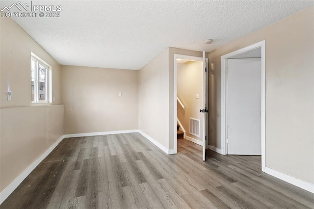 spare room with wood-type flooring and a textured ceiling