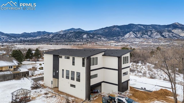 exterior space with a mountain view and stucco siding