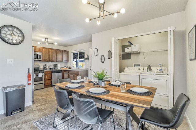 dining area featuring washer and clothes dryer, sink, and a notable chandelier