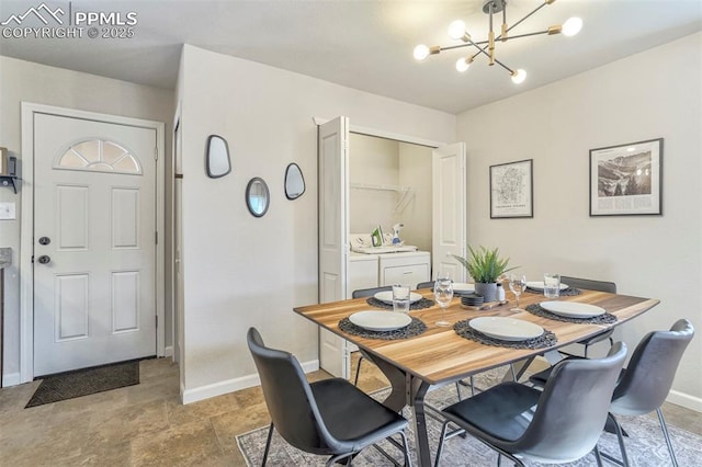 dining room with separate washer and dryer and a chandelier