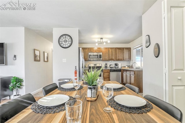 dining area featuring sink and an inviting chandelier