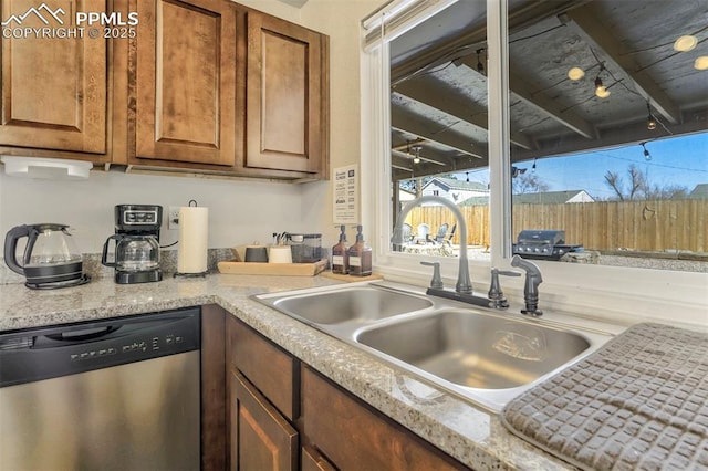 kitchen with dishwasher, sink, and light stone counters