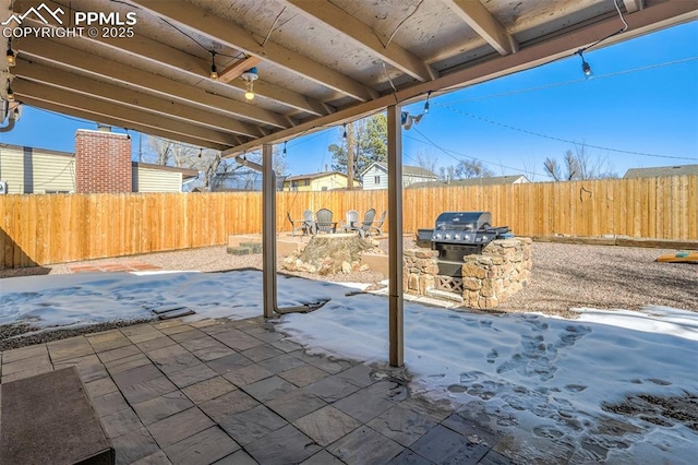 snow covered patio with area for grilling