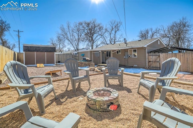 view of patio / terrace with a shed and a fire pit