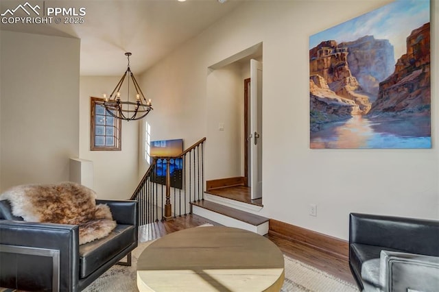 sitting room featuring wood finished floors, an upstairs landing, and a notable chandelier