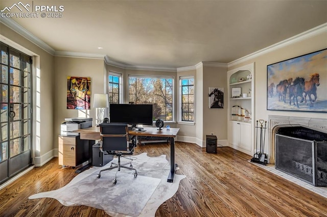 office space featuring light wood-style floors, a premium fireplace, baseboards, and built in shelves