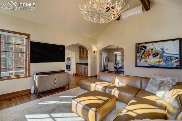 living room with arched walkways, dark wood-style flooring, an inviting chandelier, an AC wall unit, and beam ceiling