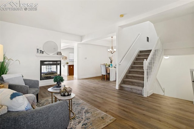 living room with a multi sided fireplace, dark wood-type flooring, and an inviting chandelier